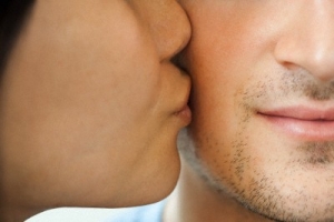 Woman kissing man on cheek